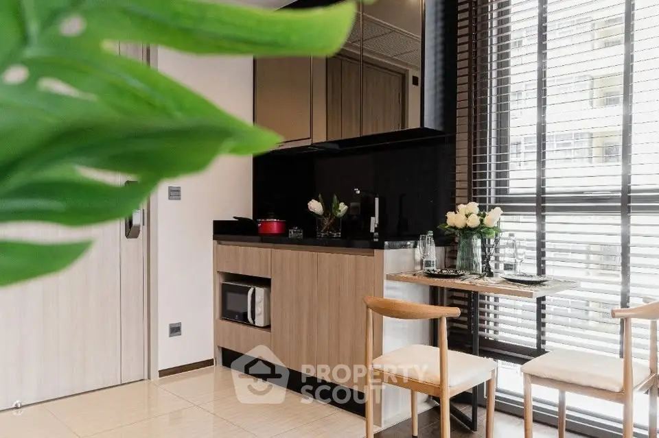 Modern kitchen with sleek design and natural light, featuring dining area and stylish decor.