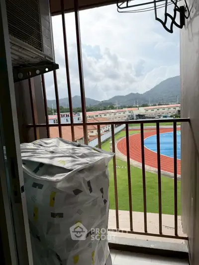 Balcony view with mountains and athletic track, perfect for sports enthusiasts.