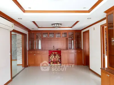 Spacious living room with elegant wooden cabinetry and modern lighting