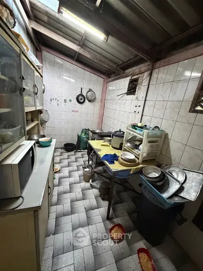 Cozy kitchen with tiled walls and essential appliances, featuring a gas stove and ample storage space.