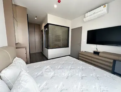 Modern bedroom with sleek design and wall-mounted TV in a stylish apartment.