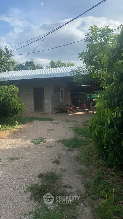 Charming rural property with lush greenery and rustic exterior, perfect for serene living.