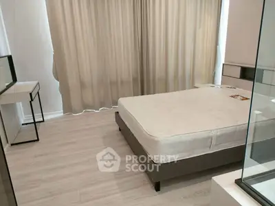 Modern bedroom with minimalist design and large windows for natural light.