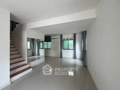 Spacious modern living room with sleek staircase and large windows