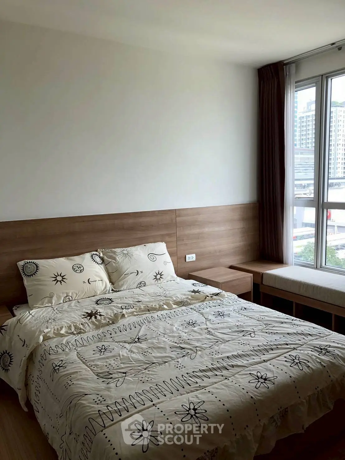 Cozy bedroom with large window and modern decor in urban apartment