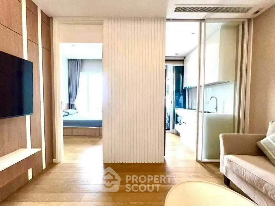 Modern apartment interior with open layout, featuring a cozy living area, sleek kitchen, and bright bedroom.