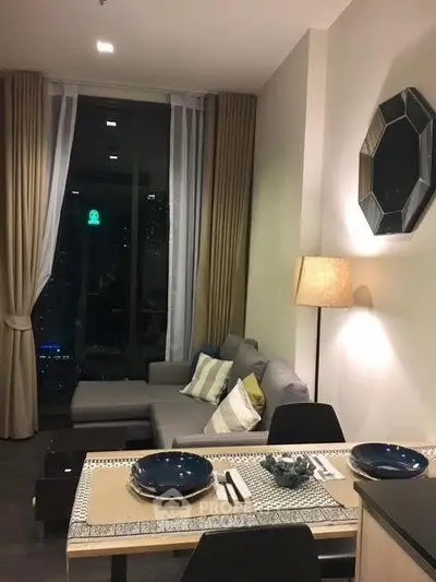 Modern living room with stylish decor and dining area in a cozy apartment setting.