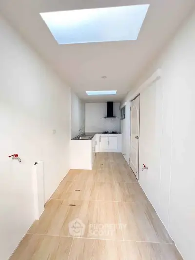 Modern minimalist kitchen with skylights and sleek cabinetry