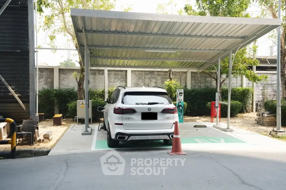 Modern parking area with electric vehicle charging station and covered carport.
