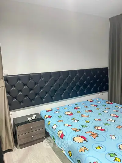 Cozy bedroom with stylish headboard and playful bedding in modern apartment.