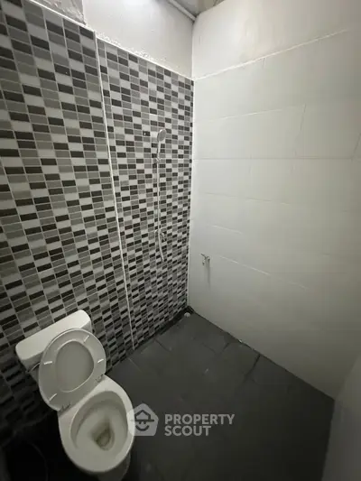 Modern bathroom with sleek black and white tiles and minimalist design.