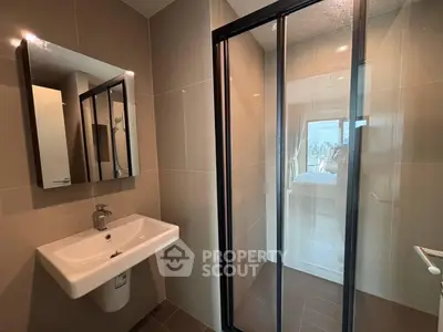 Modern bathroom with sleek design and glass shower enclosure in urban apartment.