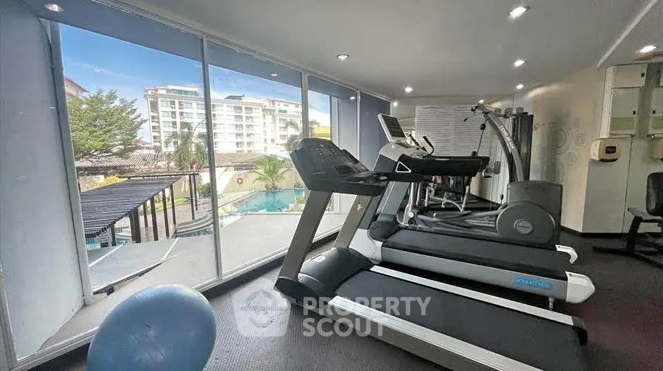 Modern gym with pool view in luxury apartment complex