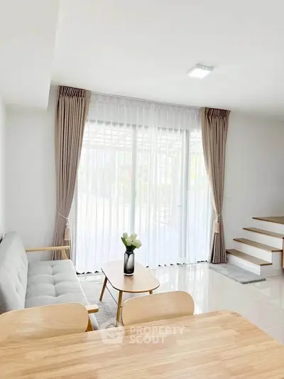 Bright modern living room with large windows and elegant decor