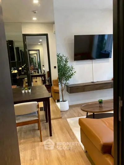 Modern living room with sleek furniture and wall-mounted TV, featuring a stylish open layout and wooden flooring.