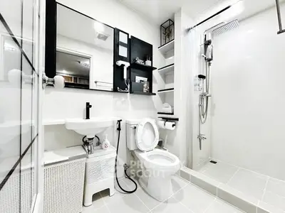 Modern white bathroom with sleek fixtures and spacious shower area.