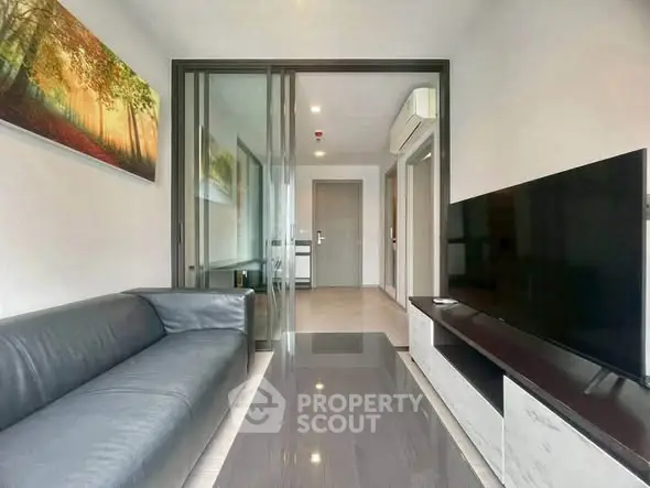 Modern living room with sleek design, featuring a large TV and comfortable sofa, perfect for relaxation.
