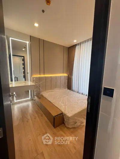 Modern bedroom with stylish lighting and wooden flooring in a contemporary apartment.