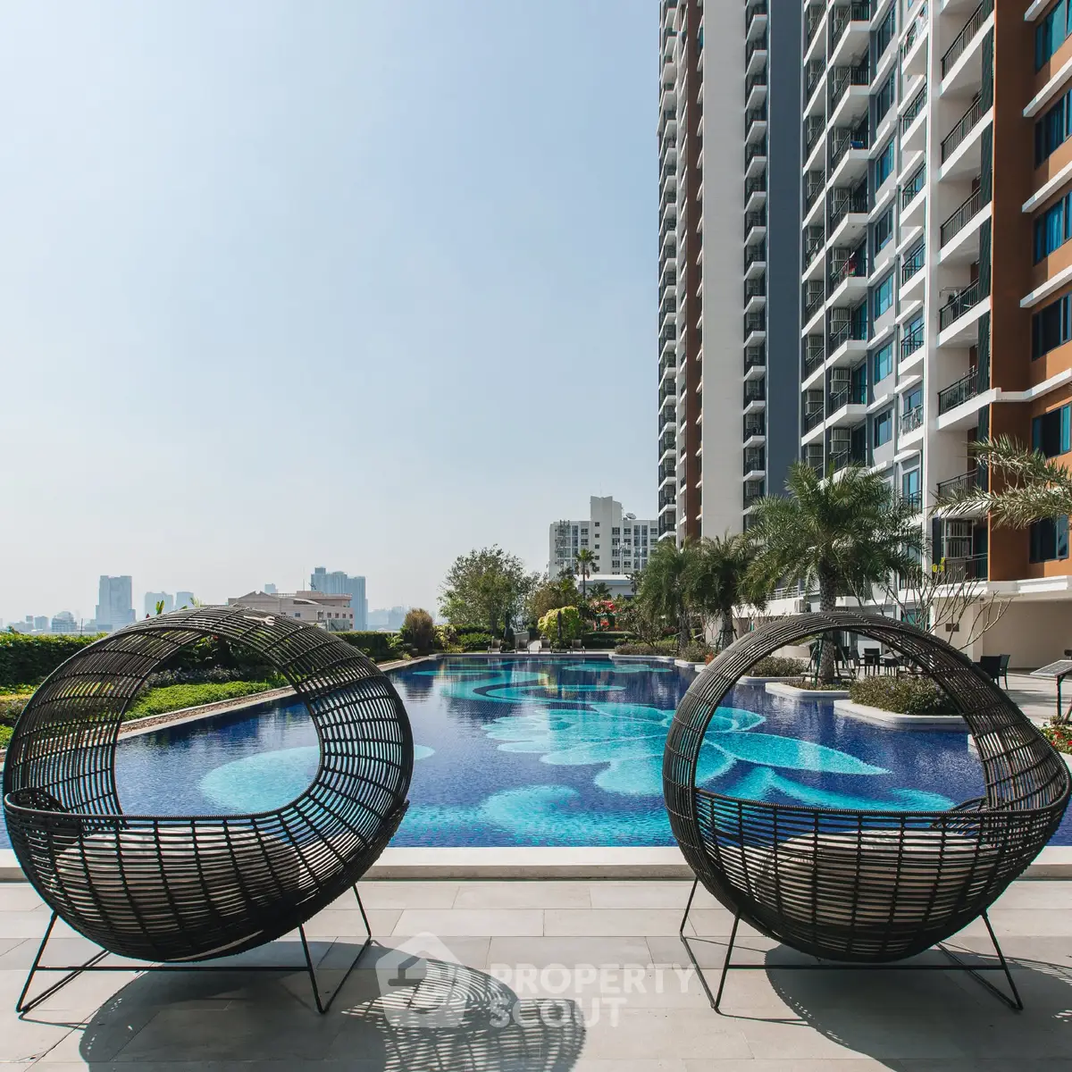 Luxurious high-rise apartment with stunning poolside view and modern outdoor seating.