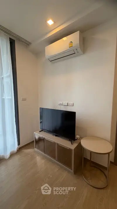 Modern living room with air conditioning and sleek TV setup in a cozy apartment.