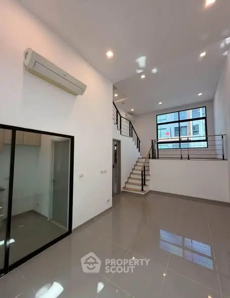 Spacious modern living room with high ceiling and large windows