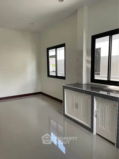 Modern kitchen with sleek cabinetry and large windows for natural light.
