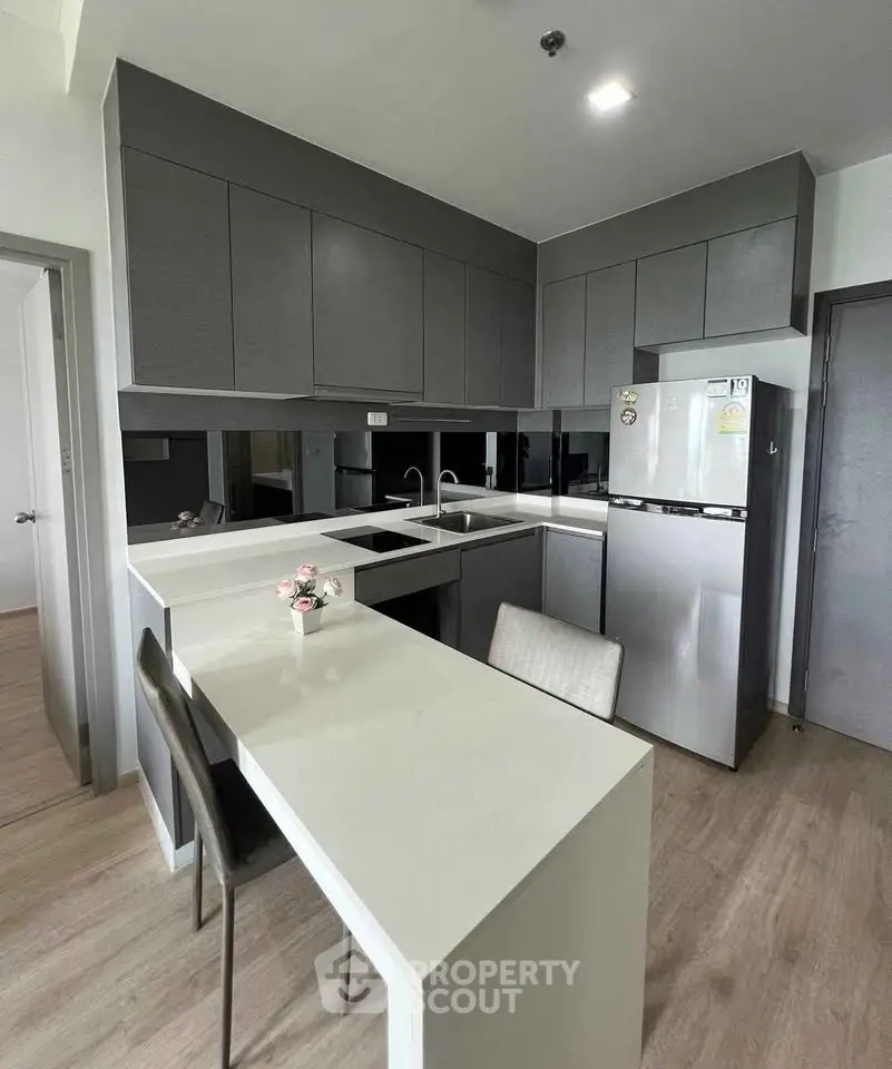 Modern kitchen with sleek cabinetry and breakfast bar in a stylish apartment.