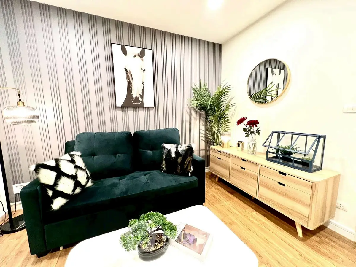 Stylish living room with modern decor, green sofa, and elegant wooden furniture.