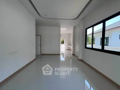 Spacious modern living room with large windows and glossy tile flooring