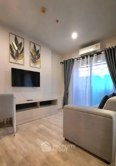 Modern living room with stylish decor and natural light, featuring a wall-mounted TV and elegant curtains.