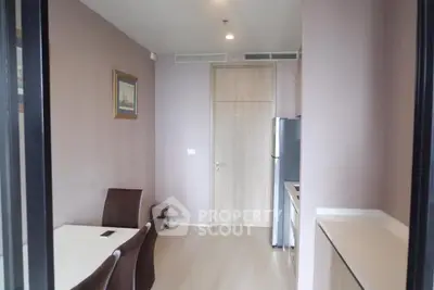 Modern dining area with sleek kitchen and elegant decor in a stylish apartment.