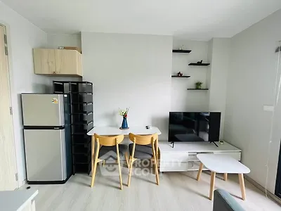 Modern living room with sleek furniture and compact design, featuring a TV and dining area.