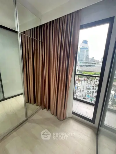 Modern apartment with floor-to-ceiling windows and city view from balcony.