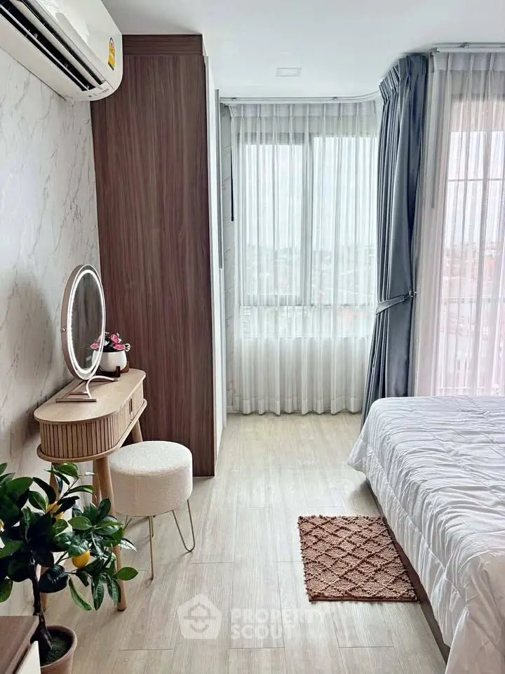 Bright and cozy bedroom with modern decor and large window view.