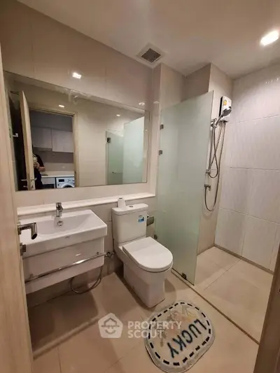 Modern bathroom with glass shower and sleek fixtures in a contemporary apartment.