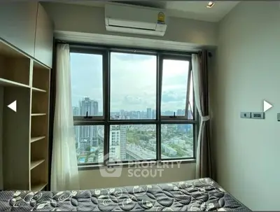 Modern bedroom with large window offering stunning city view, featuring air conditioning and stylish decor.