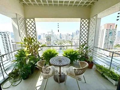 Stunning balcony with city skyline view, lush greenery, and cozy seating area.