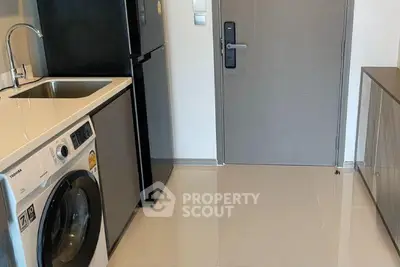 Modern apartment entryway with washing machine and sleek appliances