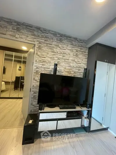 Modern living room with stylish stone accent wall and sleek entertainment center.