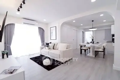 Modern open-plan living room with elegant dining area and natural light