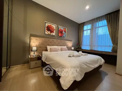 Luxurious bedroom with elegant decor and large window for natural light.
