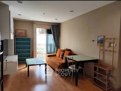 Cozy living room with modern furniture and balcony view in urban apartment.