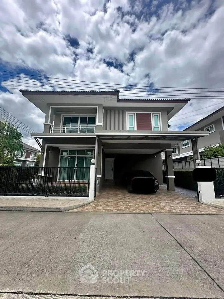 Modern two-story house with spacious driveway and sleek exterior design.
