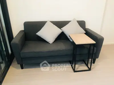 Modern living room with stylish gray sofa and sleek side table, perfect for cozy relaxation.