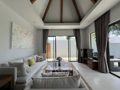 Luxurious living room with high ceilings and modern decor, featuring large windows and elegant furnishings.