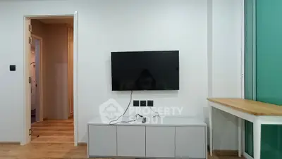 Modern living room with wall-mounted TV and sleek storage unit