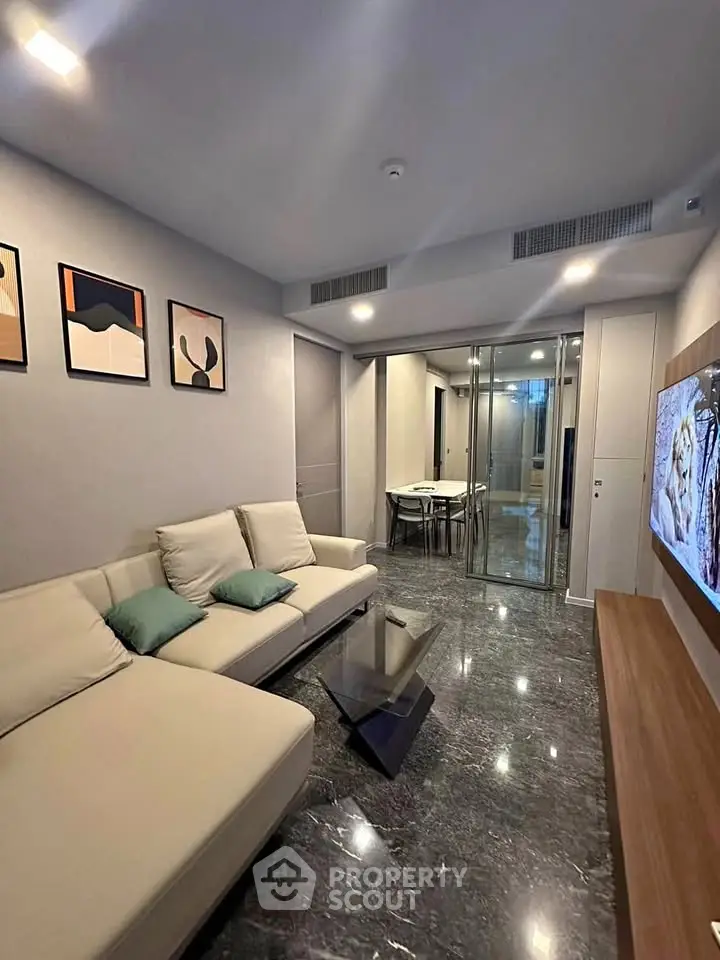 Modern living room with sleek design and stylish decor, featuring a comfortable sofa and wall-mounted TV.