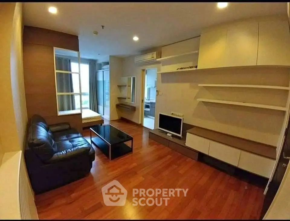 Spacious living room with modern furnishings and wooden flooring in a stylish apartment.