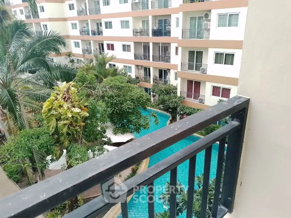 Stunning view of modern apartment complex with lush greenery and inviting swimming pool.