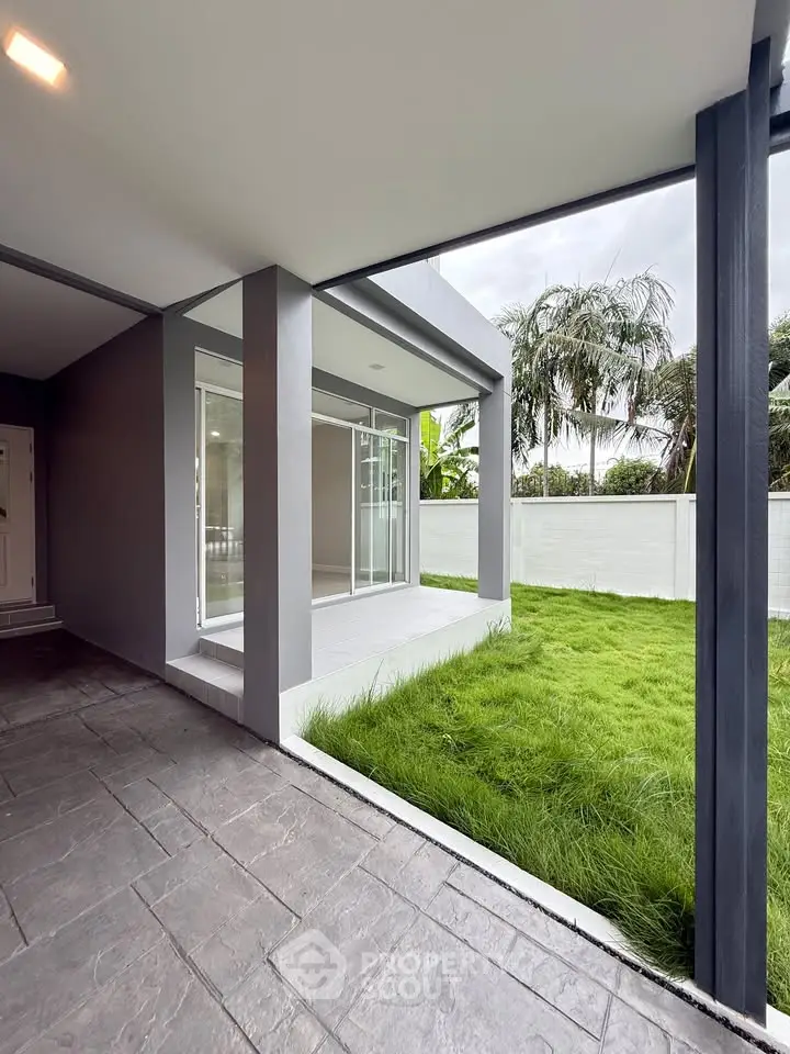 Modern home exterior with lush green lawn and sleek architectural design.